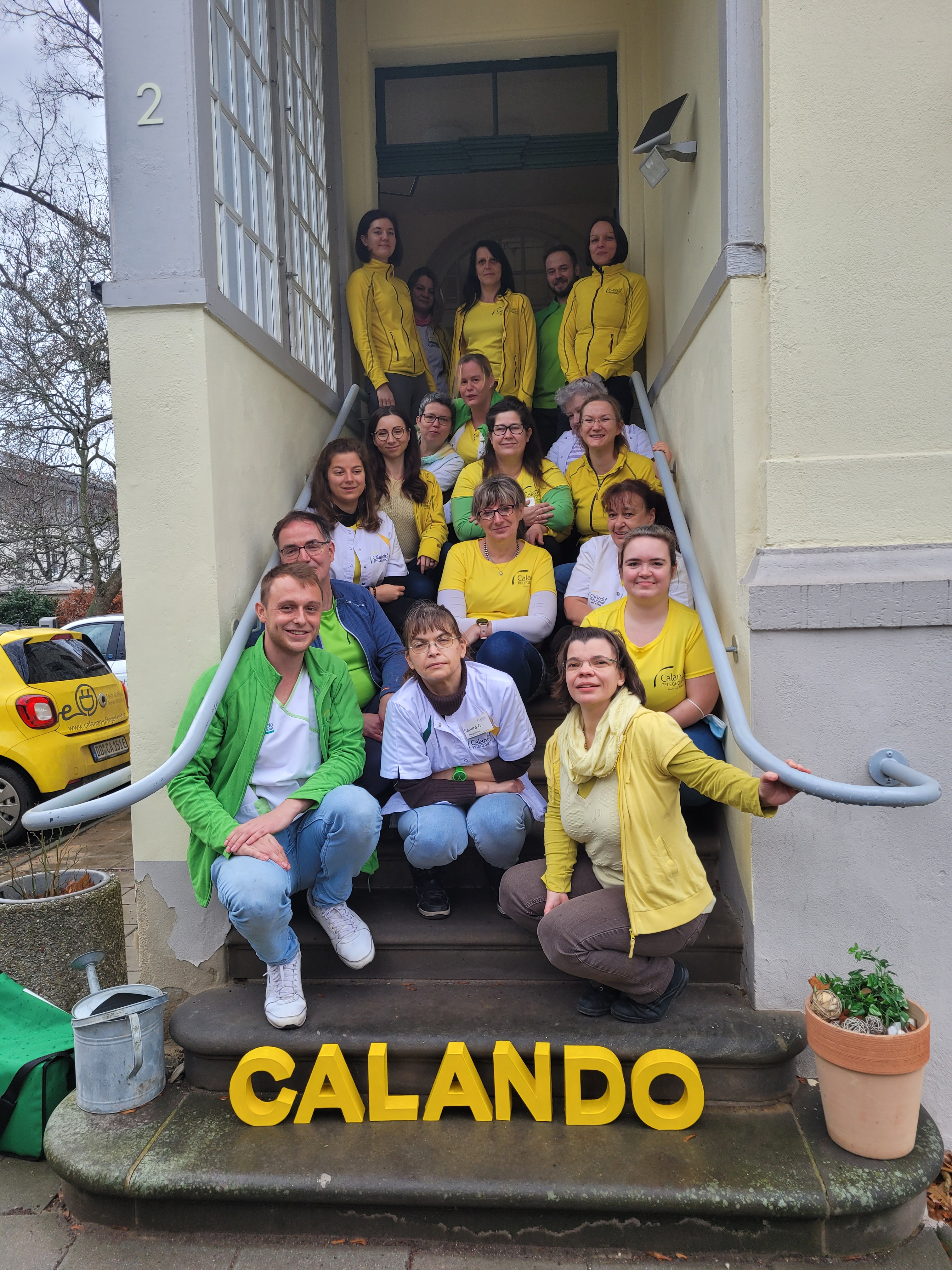 Teamfoto auf der Eingangstreppe zum Calando Pflegedienst in Dresden